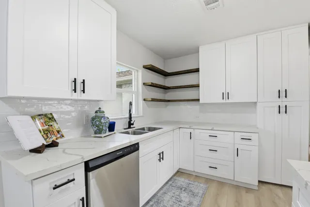a kitchen with white cabinets and white appliances