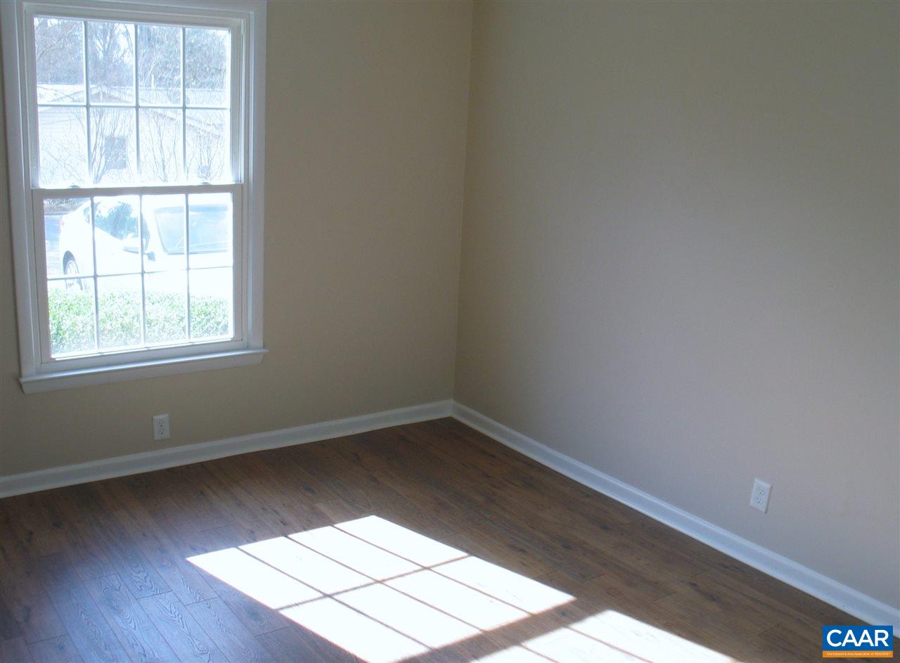 2527 Hydraulic Road, Unit 1 Charlottesville, VA 22901 - Photo 14 of 25 an empty room with wooden floor and windows