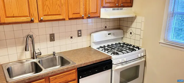 a kitchen with a sink a stove and a microwave