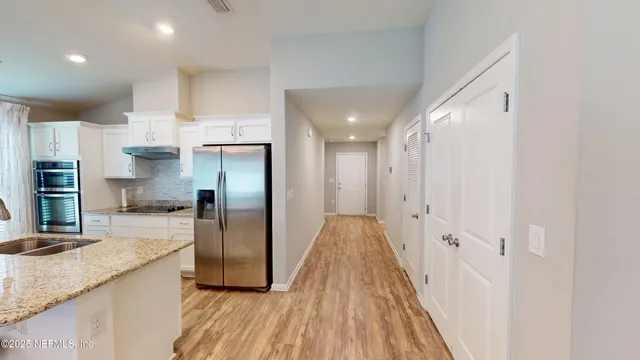 a kitchen with stainless steel appliances granite countertop a refrigerator a sink and a stove