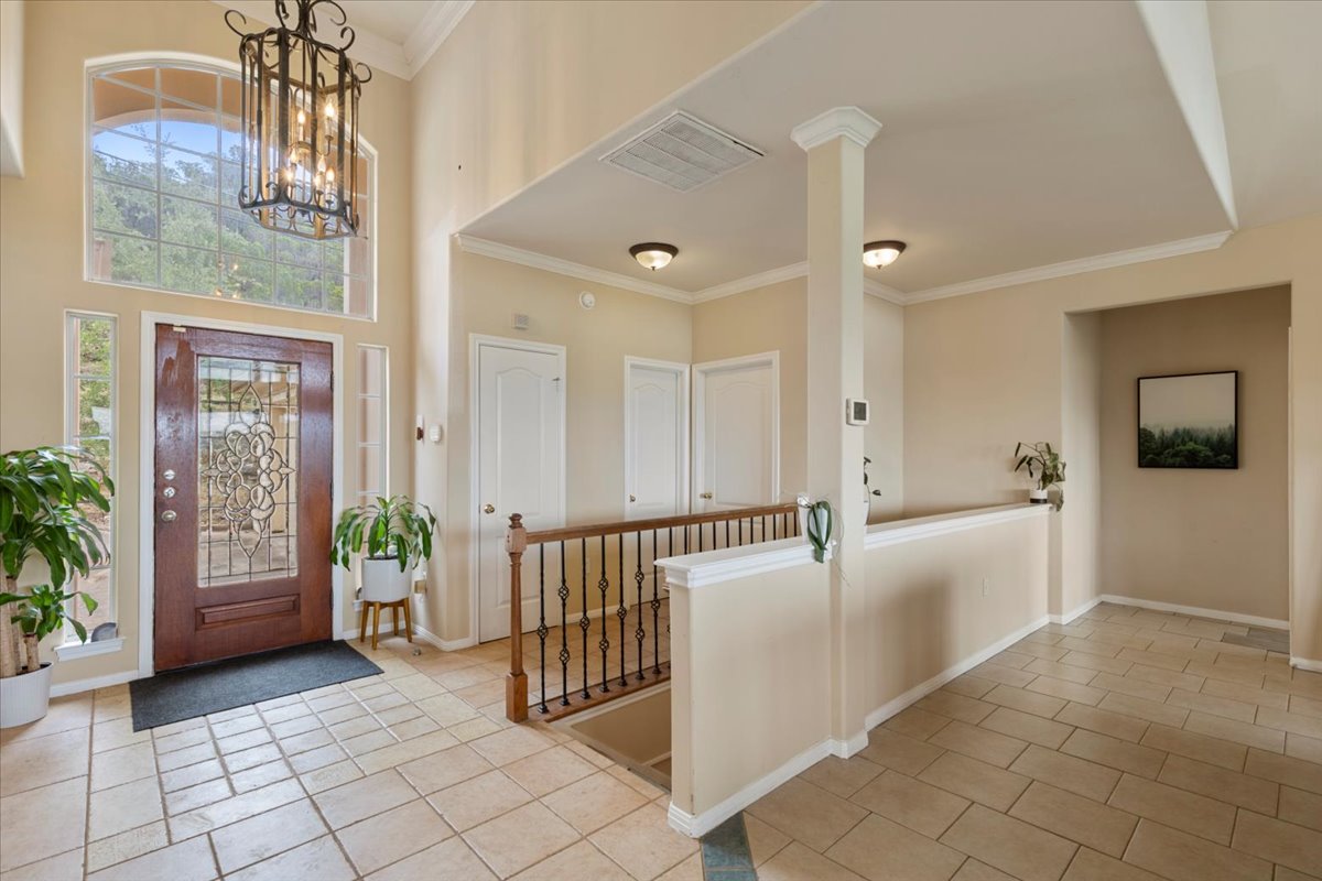 13612 Bullick Hollow Road Austin, TX 78726 - Photo 3 of 34 a view of a hallway with dining area and chandelier