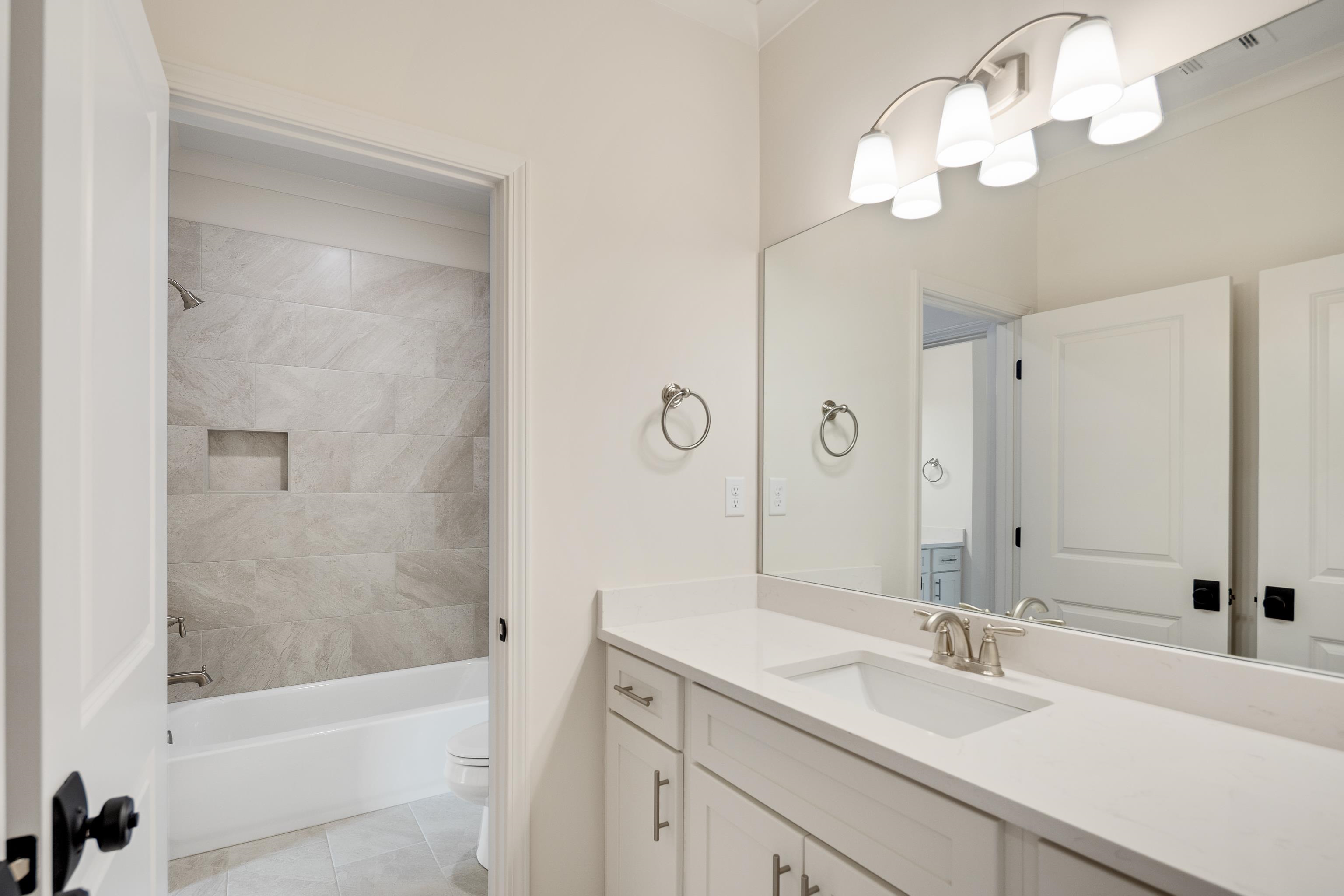 284 Keisie Lane Collierville, TN 38017 - Photo 25 of 34 Bathroom featuring a light-toned vanity with an integrated sink, a large mirror, and a four-light fixture