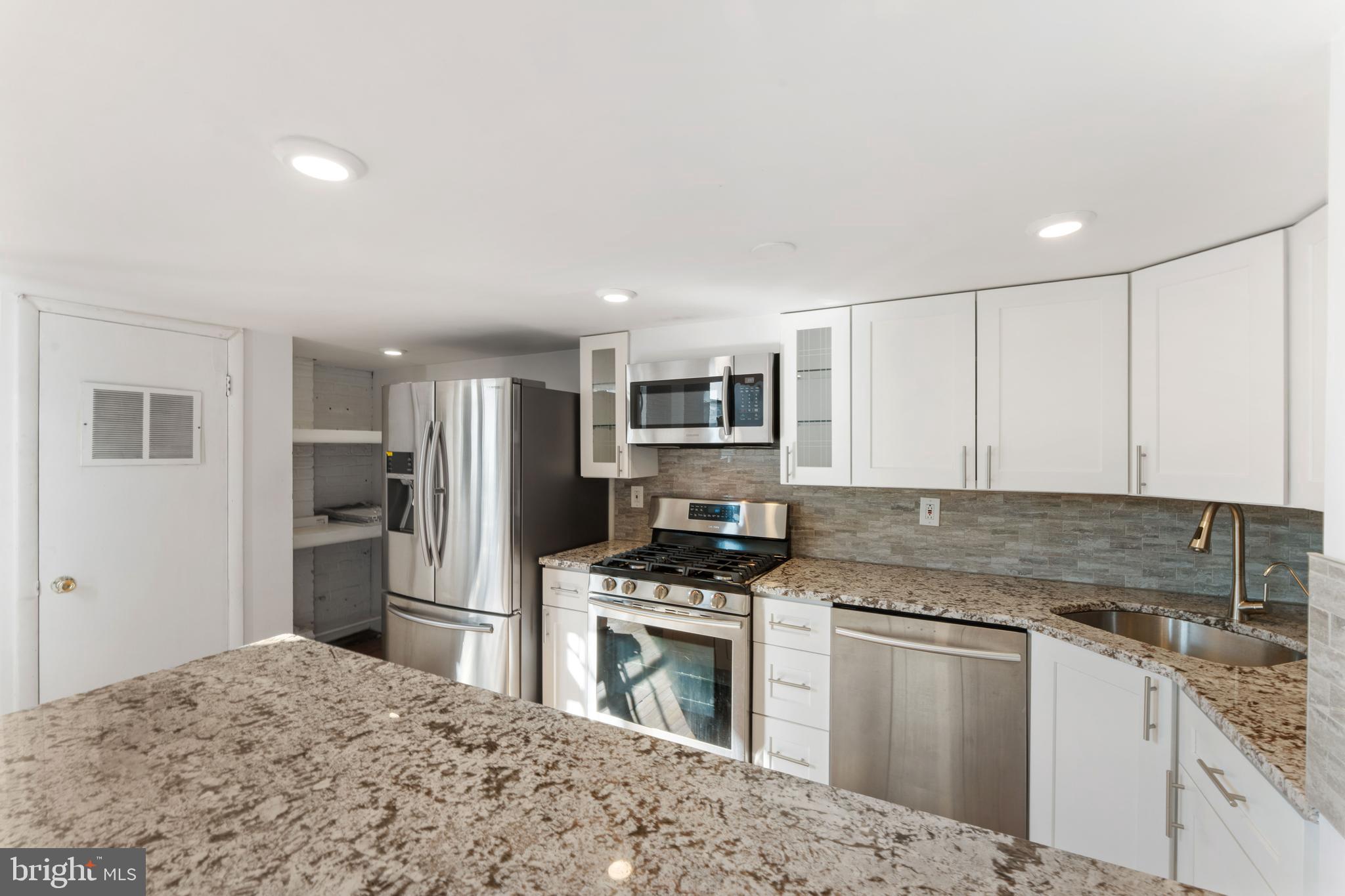 700 South 10th Street, Unit 2F Philadelphia, PA 19147 - Photo 14 of 40 a kitchen with stainless steel appliances granite countertop a refrigerator sink and stove