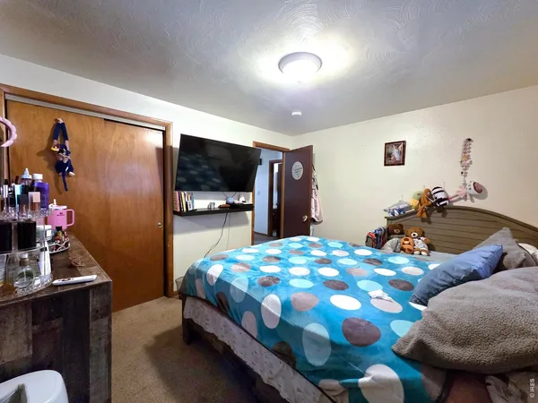 a bedroom with bed mirror and window