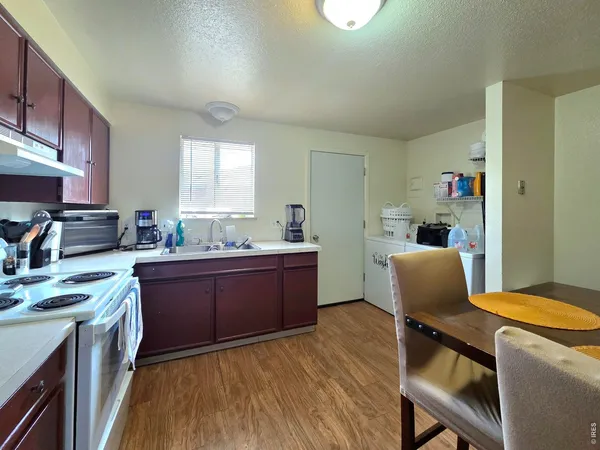 a kitchen with cabinets a sink and chairs