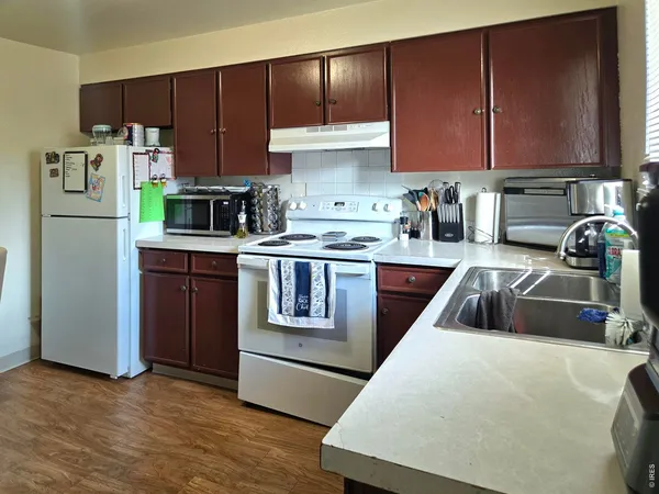 a kitchen with a refrigerator sink and cabinets