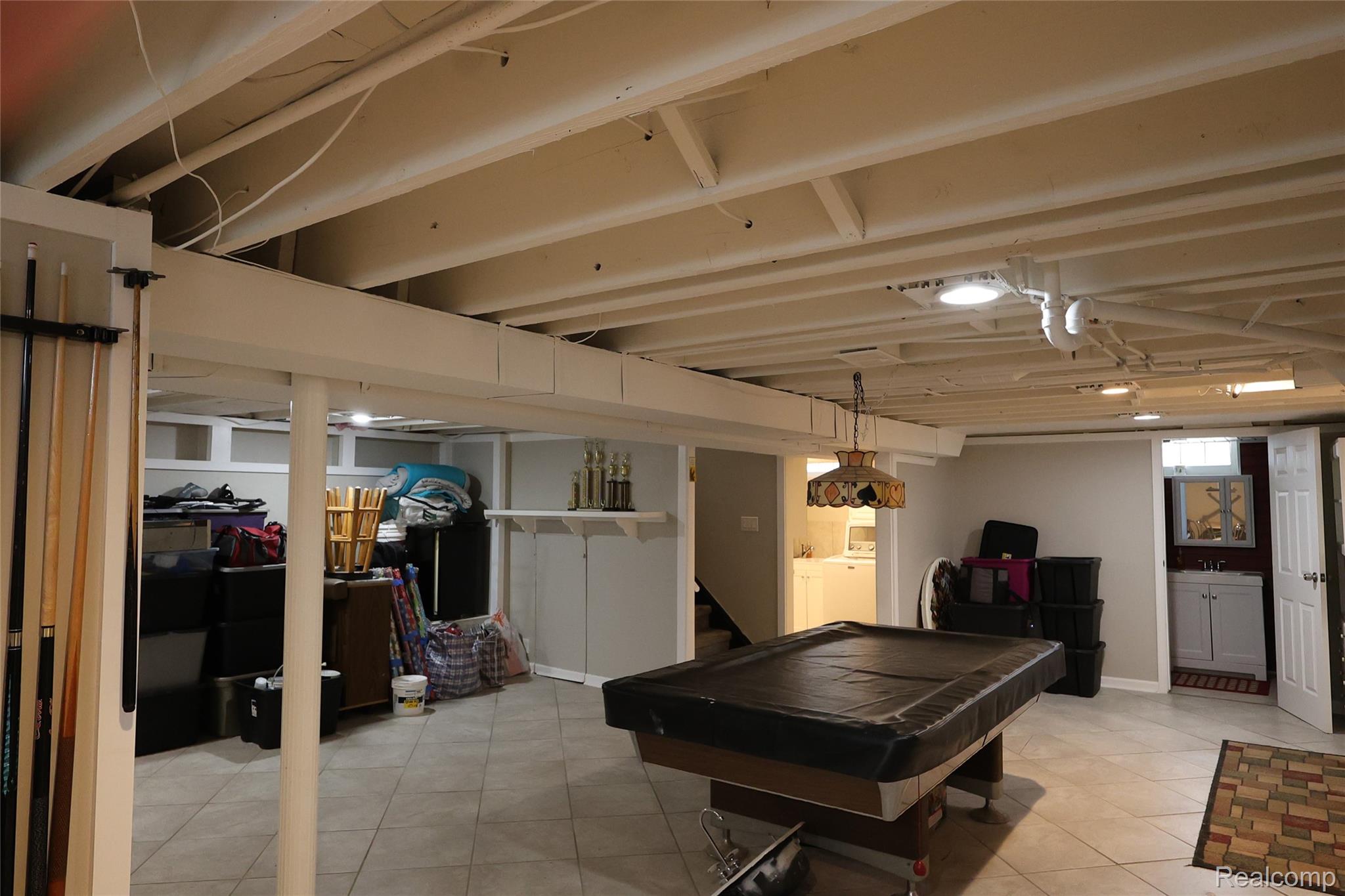 26140 Hayes Road Roseville, MI 48066 - Photo 17 of 21 Finished lower level featuring tile flooring, exposed beam ceiling, recessed lighting, and a built-in vanity with a basin sink