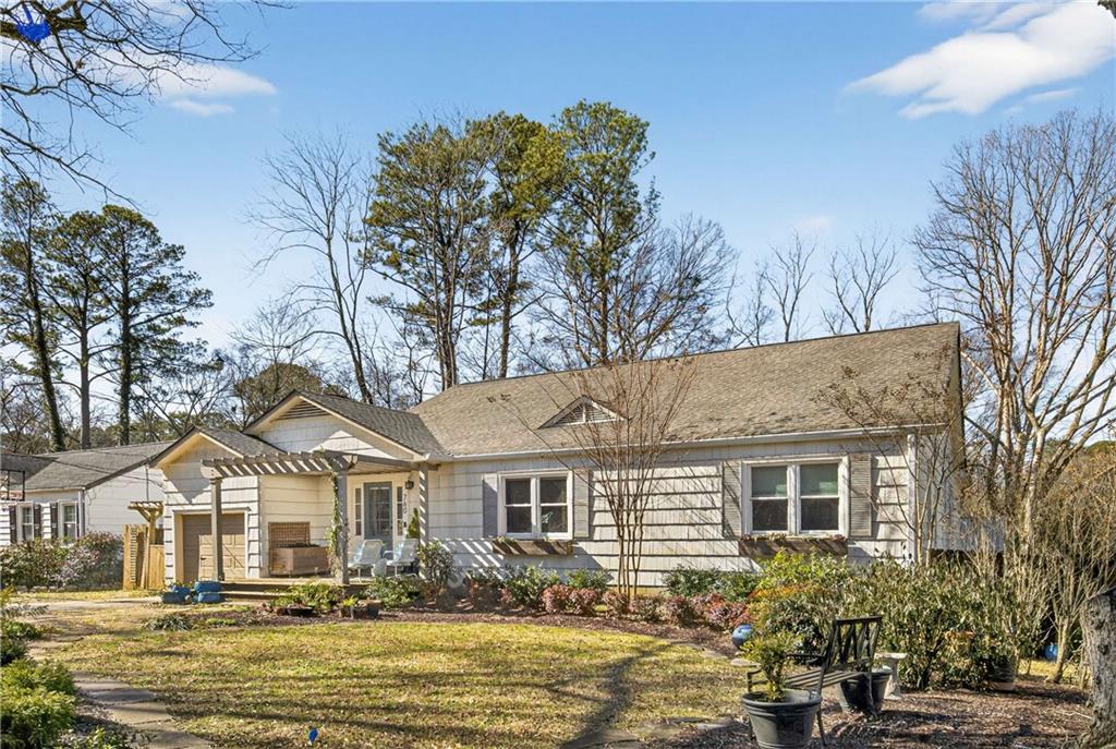 a front view of a house with a garden and trees