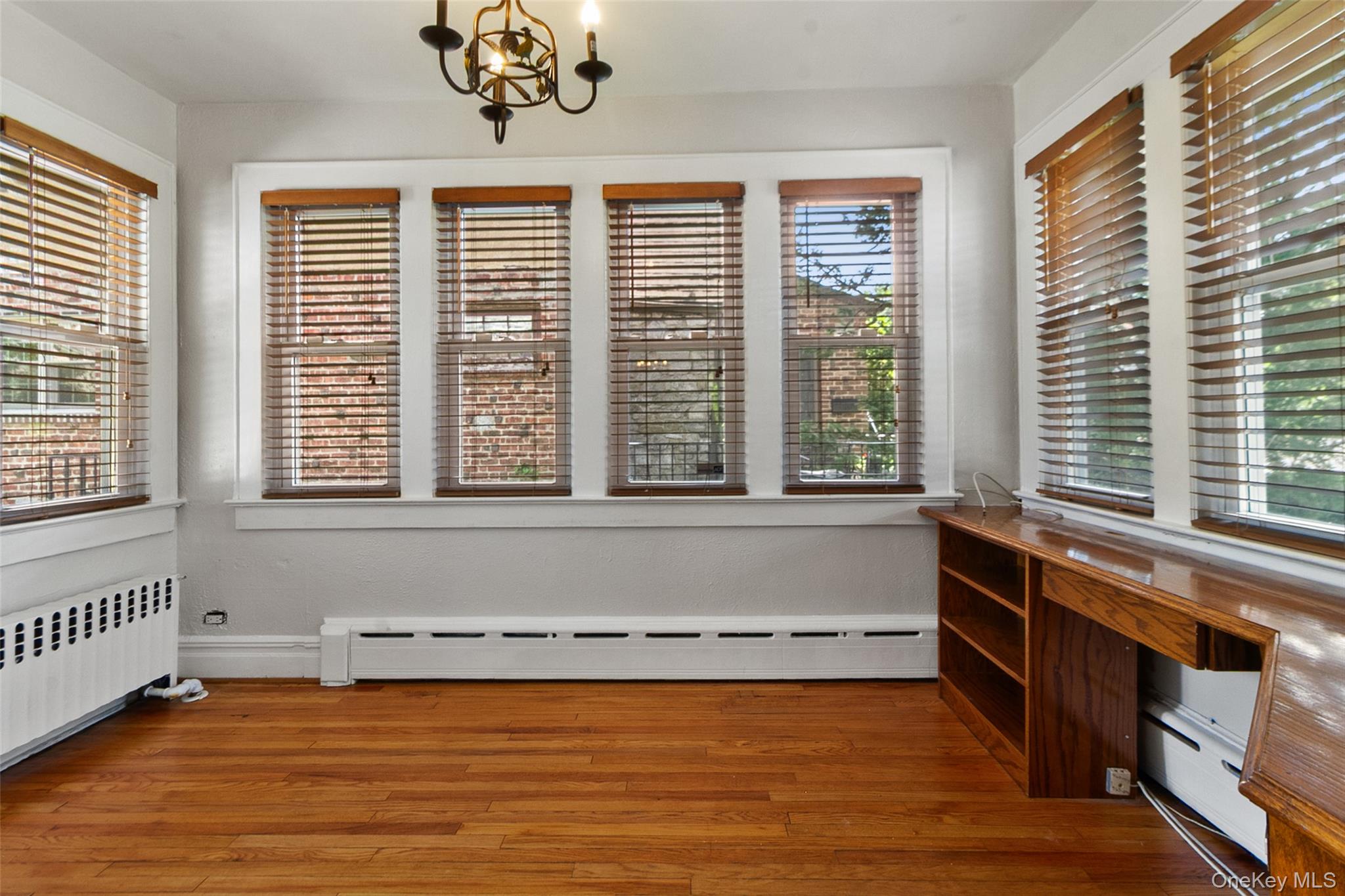 11 Crawford Street Yonkers, NY 10705 - Photo 12 of 24 Unfurnished dining area with baseboard heating, light wood-style floors, a chandelier, and a baseboard radiator