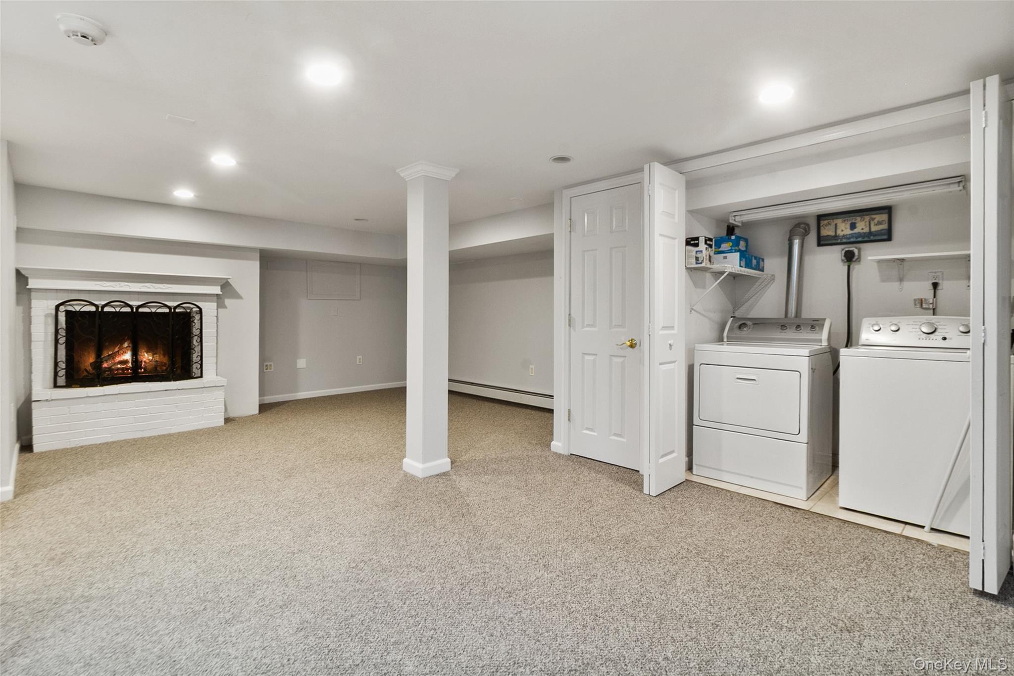11 Crawford Street Yonkers, NY 10705 - Photo 19 of 24 Finished below grade area with light colored carpet, a fireplace, separate washer and dryer, recessed lighting, and a baseboard radiator