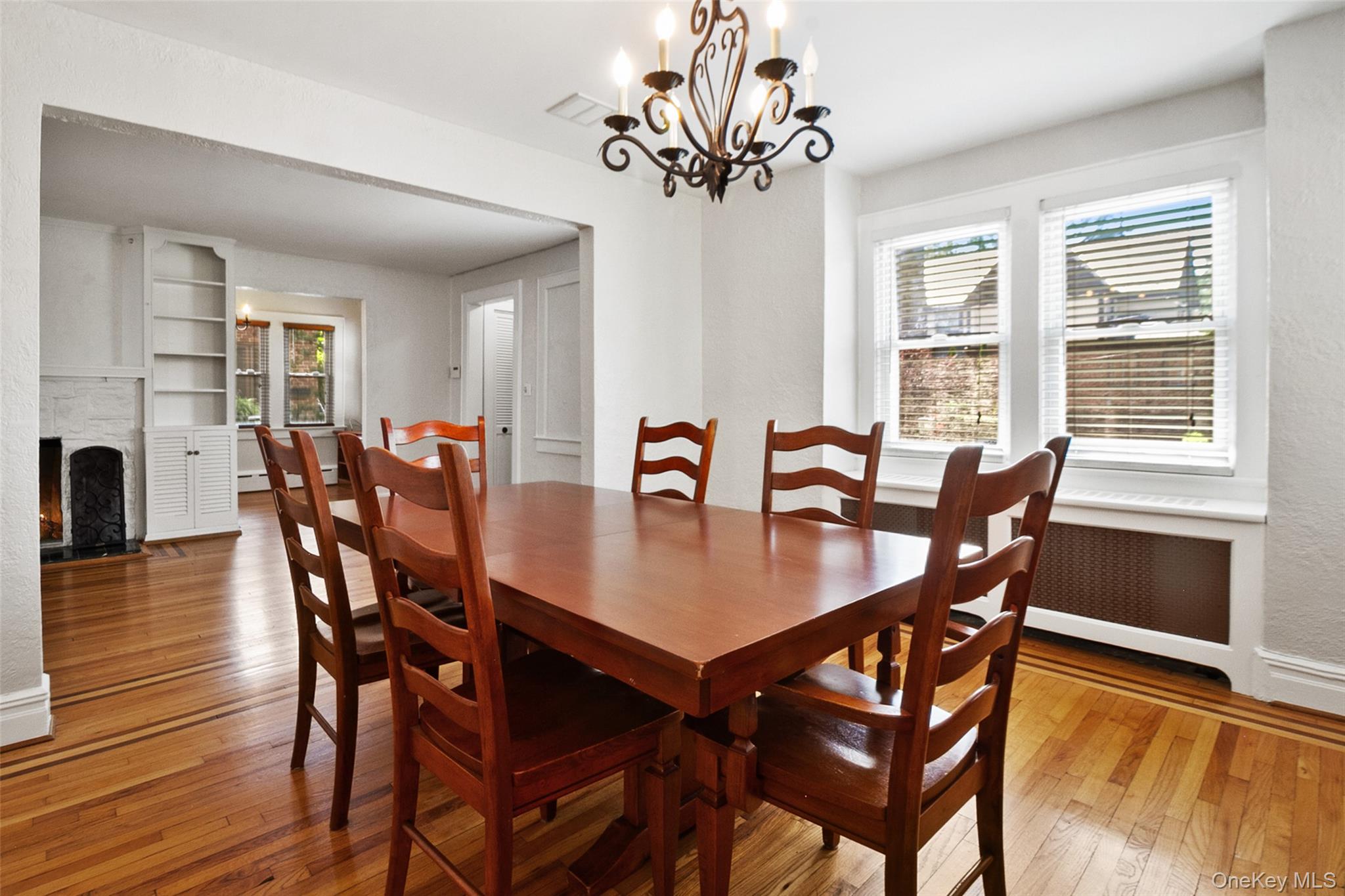 11 Crawford Street Yonkers, NY 10705 - Photo 8 of 24 Dining space featuring light wood-style floors, a chandelier, a fireplace with flush hearth, radiator heating unit, and a baseboard heating unit