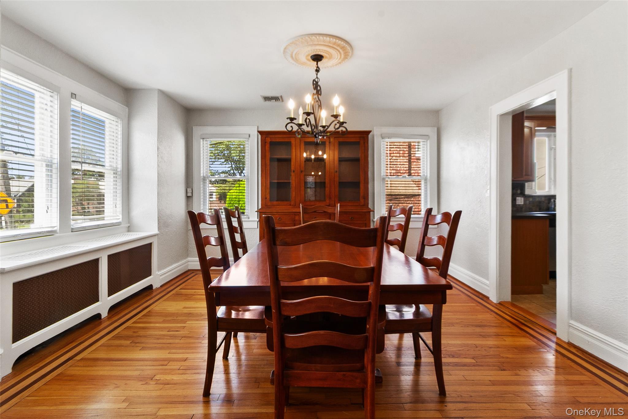 11 Crawford Street Yonkers, NY 10705 - Photo 9 of 24 Dining area with radiator, light wood-style flooring, a chandelier, and a textured wall