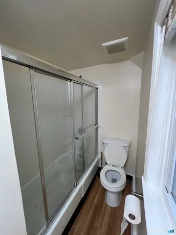 a white toilet sitting next to a shower