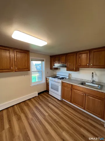 a large kitchen with stainless steel appliances granite countertop a lot of counter space and wooden floor