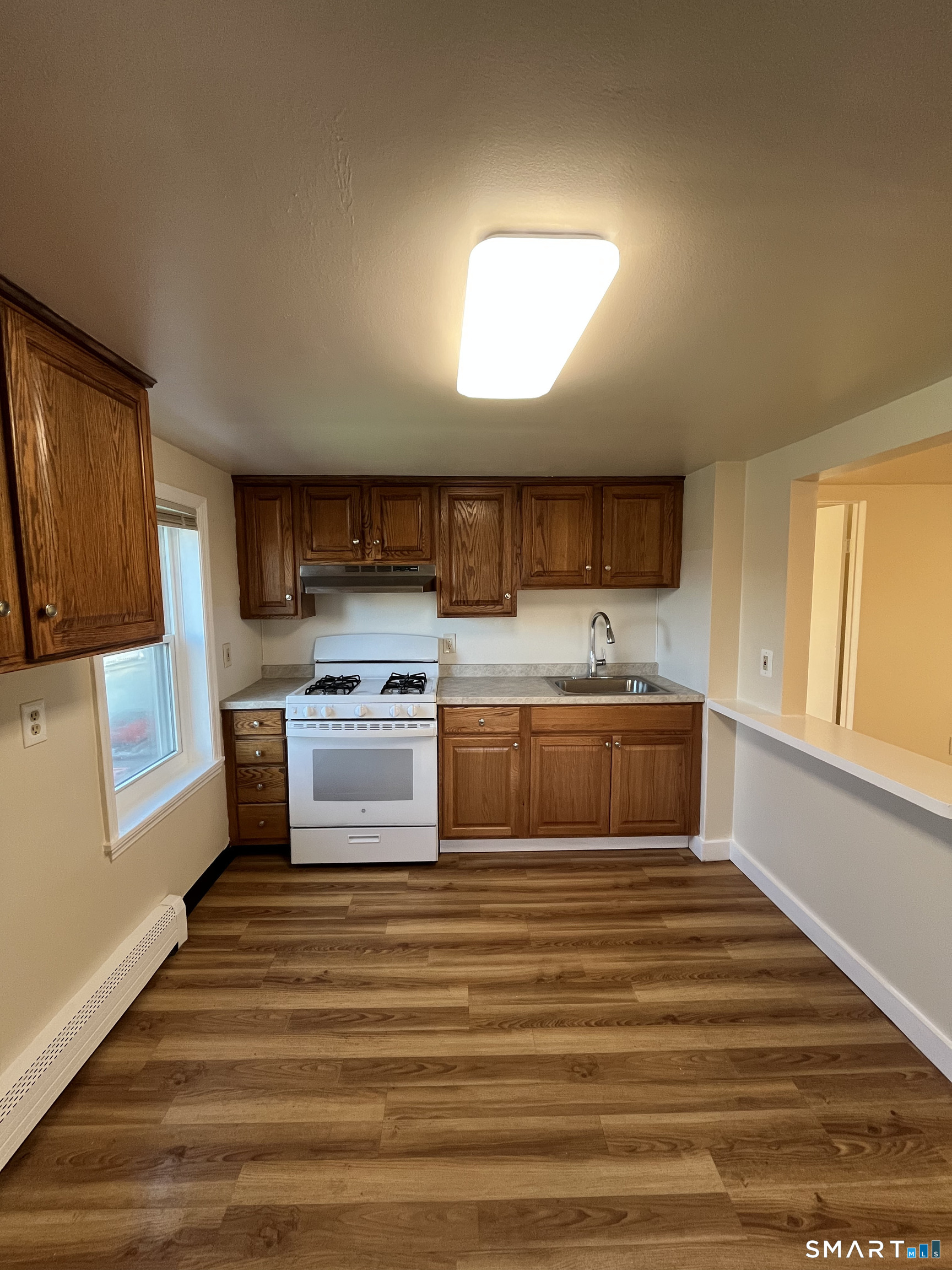 6 Pleasant Street, Unit 3 Norwalk, CT 06855 - Photo 5 of 16 a kitchen with stainless steel appliances a stove sink and cabinets