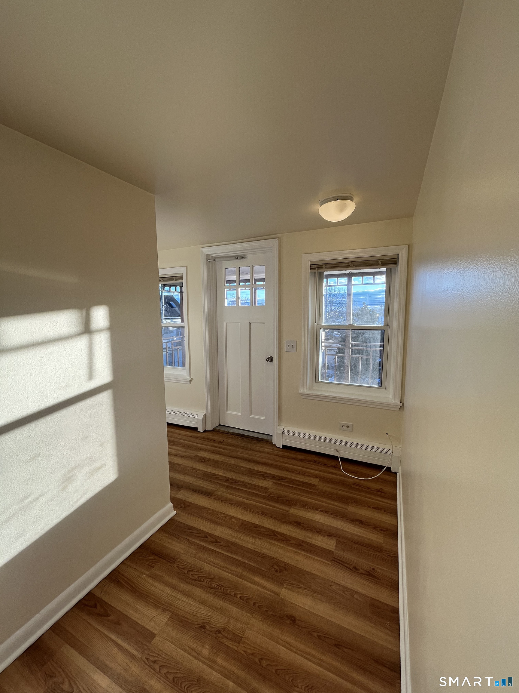 6 Pleasant Street, Unit 3 Norwalk, CT 06855 - Photo 8 of 16 a view of an empty room with wooden floor and a window
