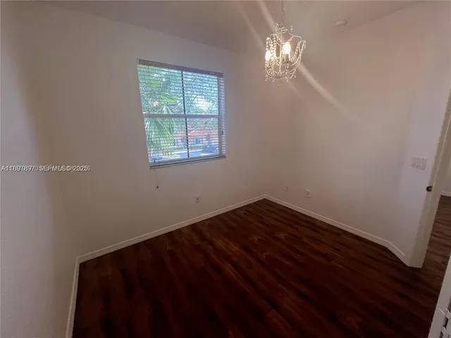a view of a room with wooden floor and a window