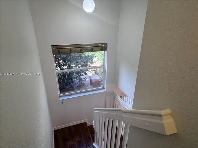 a view of a small space with wooden floor and a window