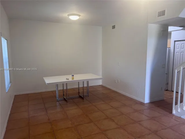 a view of a room with a table and chairs
