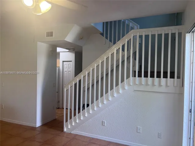 a view of staircase with railing and white walls