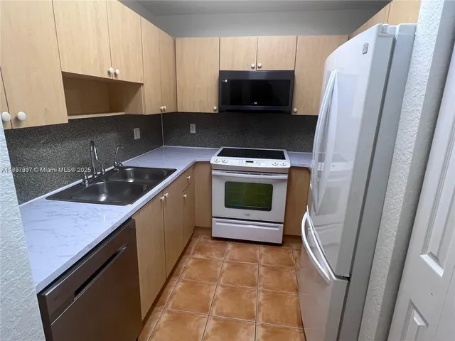 a kitchen with stainless steel appliances a stove a microwave a sink and cabinets