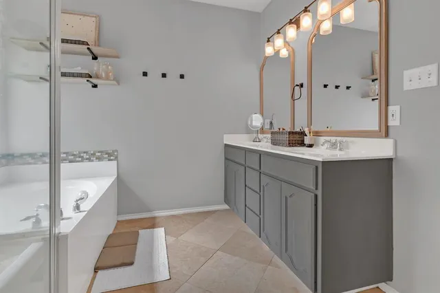 a bathroom with a sink shower and a mirror