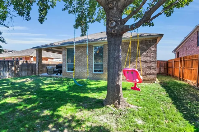 a view of a backyard with table and chairs and potted plants