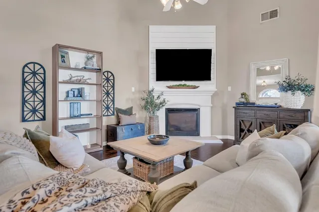 a living room with furniture a flat screen tv and a fireplace