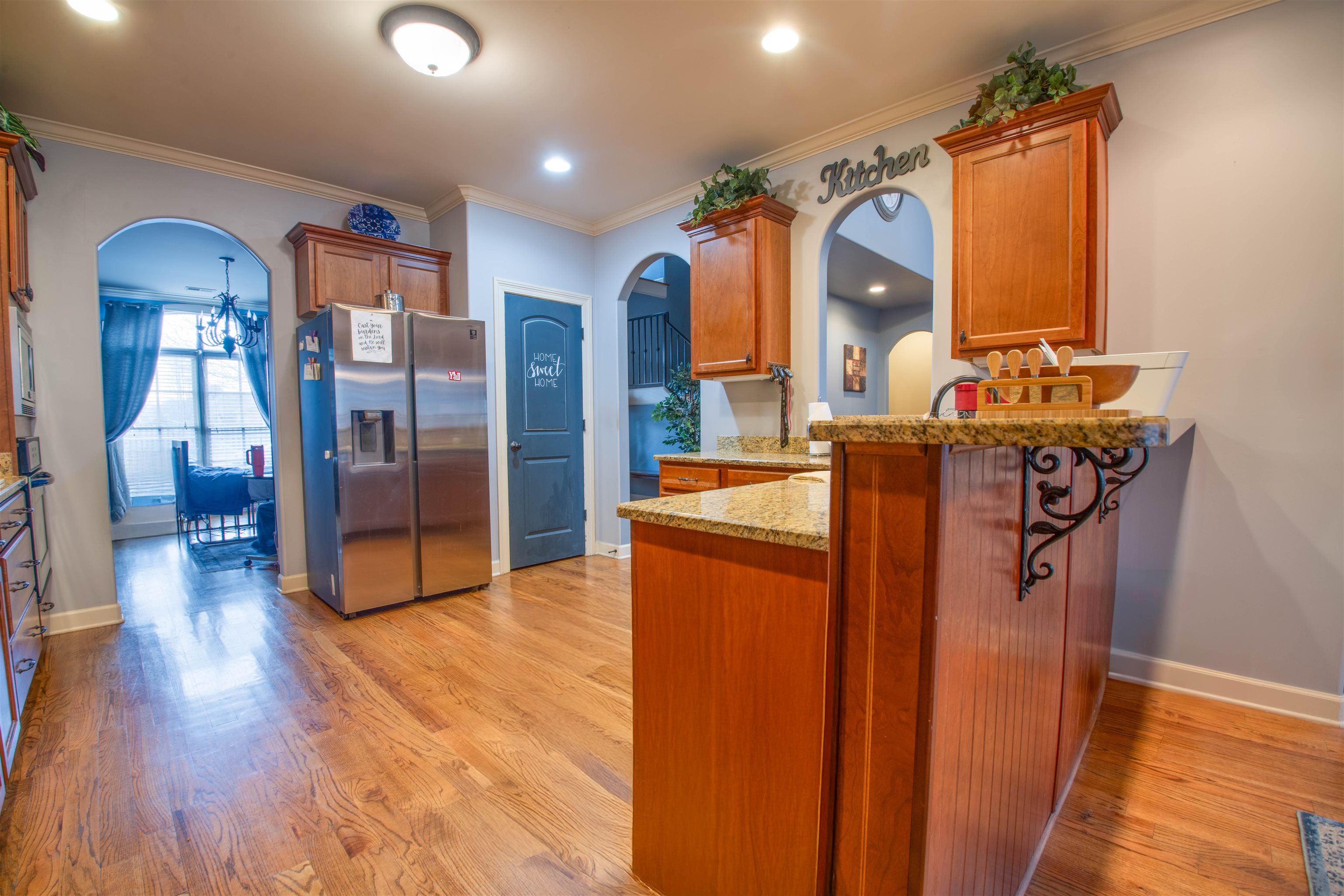 8722 Brunswick Forest Drive Bartlett, TN 38133 - Photo 11 of 38 Kitchen with light hardwood / wood-style floors, stainless steel fridge with ice dispenser, light stone countertops, and kitchen peninsula