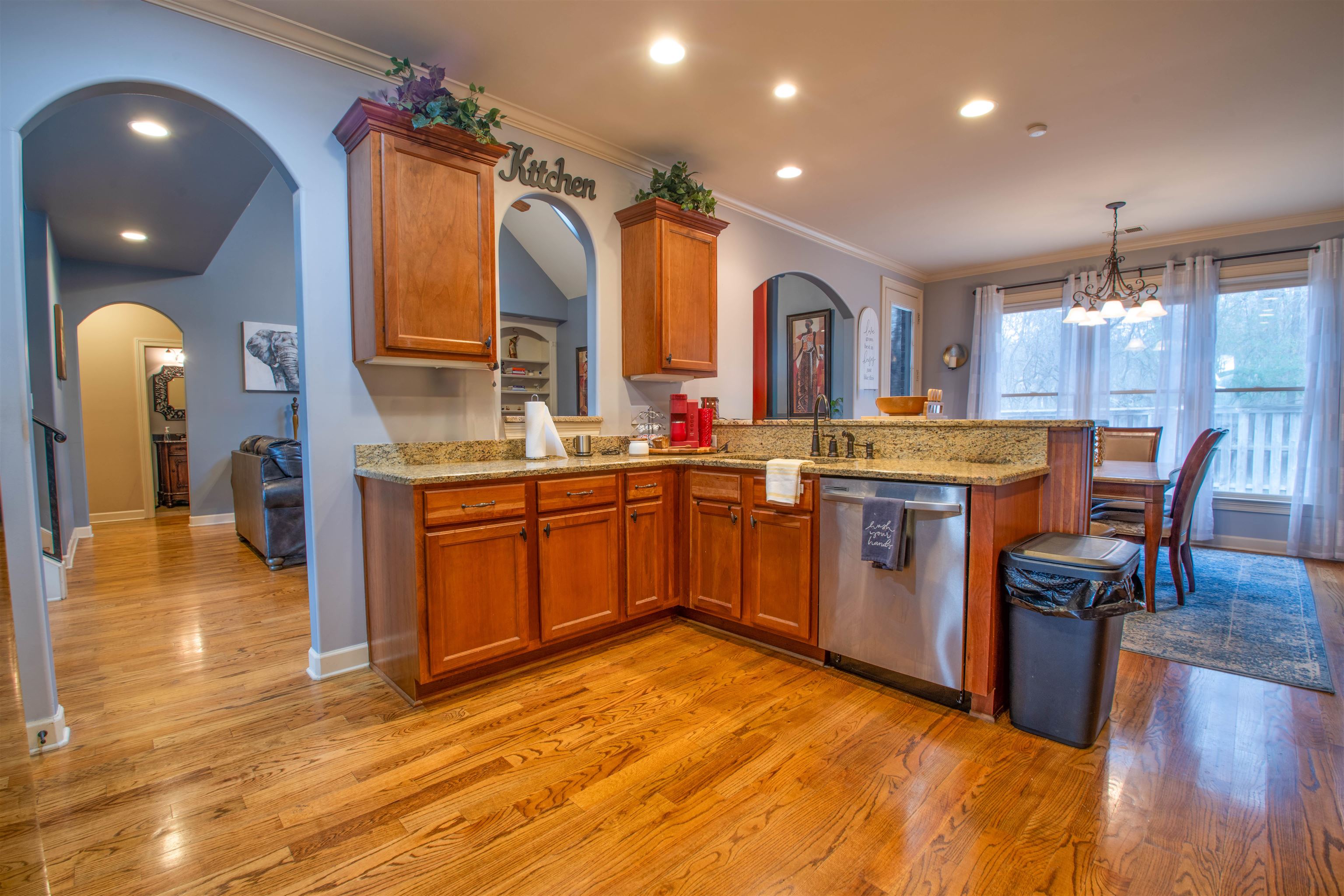 8722 Brunswick Forest Drive Bartlett, TN 38133 - Photo 12 of 38 Kitchen with stainless steel dishwasher, decorative light fixtures, kitchen peninsula, and light hardwood / wood-style floors