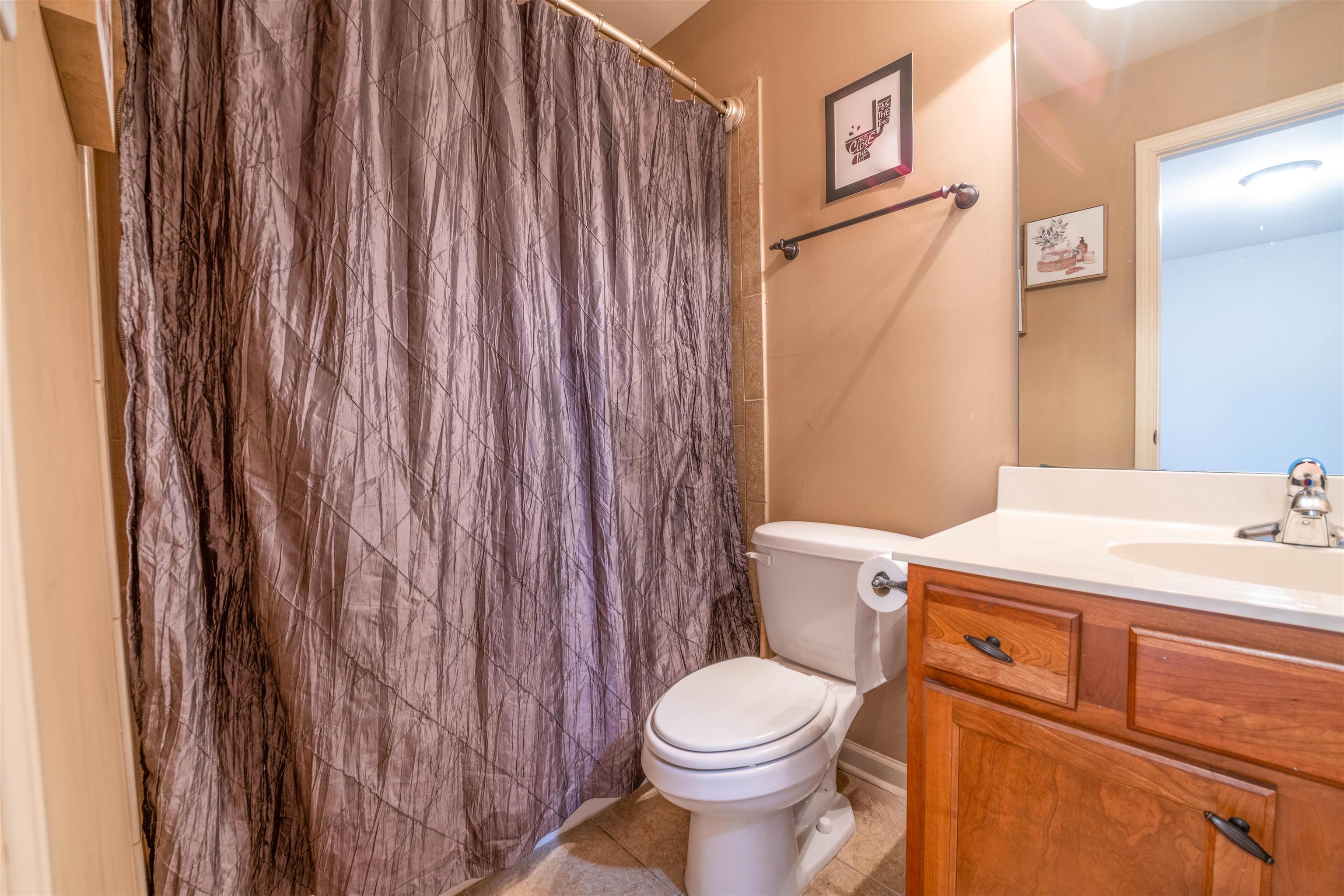 8722 Brunswick Forest Drive Bartlett, TN 38133 - Photo 30 of 38 Bathroom with a shower with curtain, tile patterned floors, vanity, and toilet- 2nd level in bedroom two