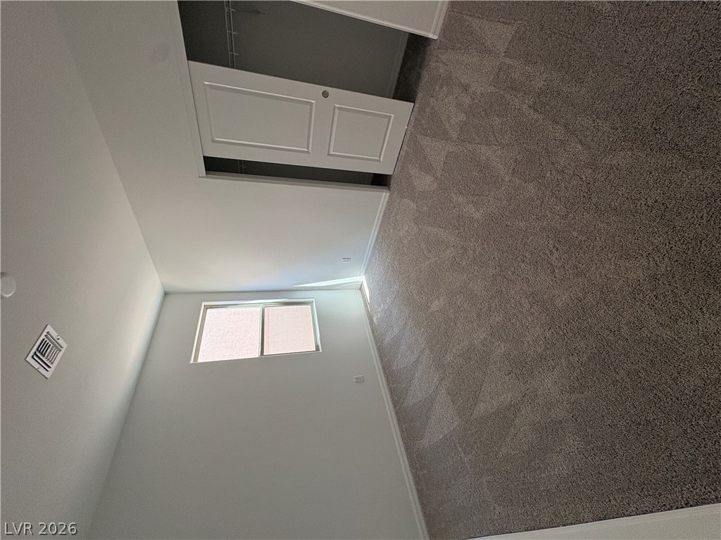 8677 South Indigo Springs Road Las Vegas, NV 89139 - Photo 4 of 9 Well-lit room features soft carpeting and high-set windows for diffused illumination.