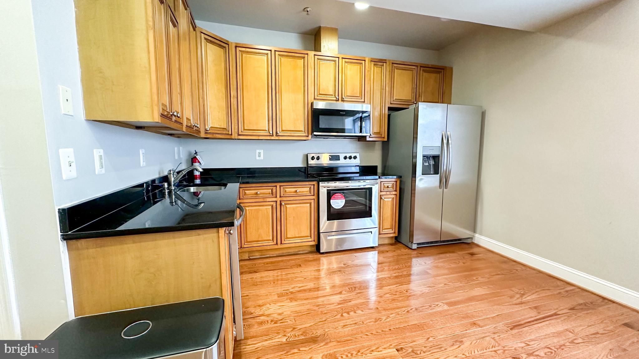 3408 Sherman Avenue Northwest, Unit 101 Washington, DC 20010 - Photo 6 of 15 a kitchen with stainless steel appliances granite countertop a stove a refrigerator and a sink
