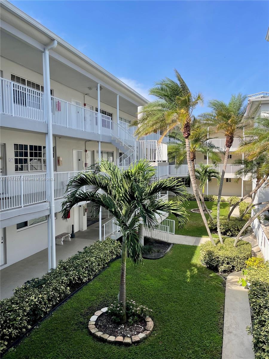 462 Golden Isles Drive, Unit 210 Hallandale Beach, FL 33009 - Photo 24 of 41 a front view of a house with a yard