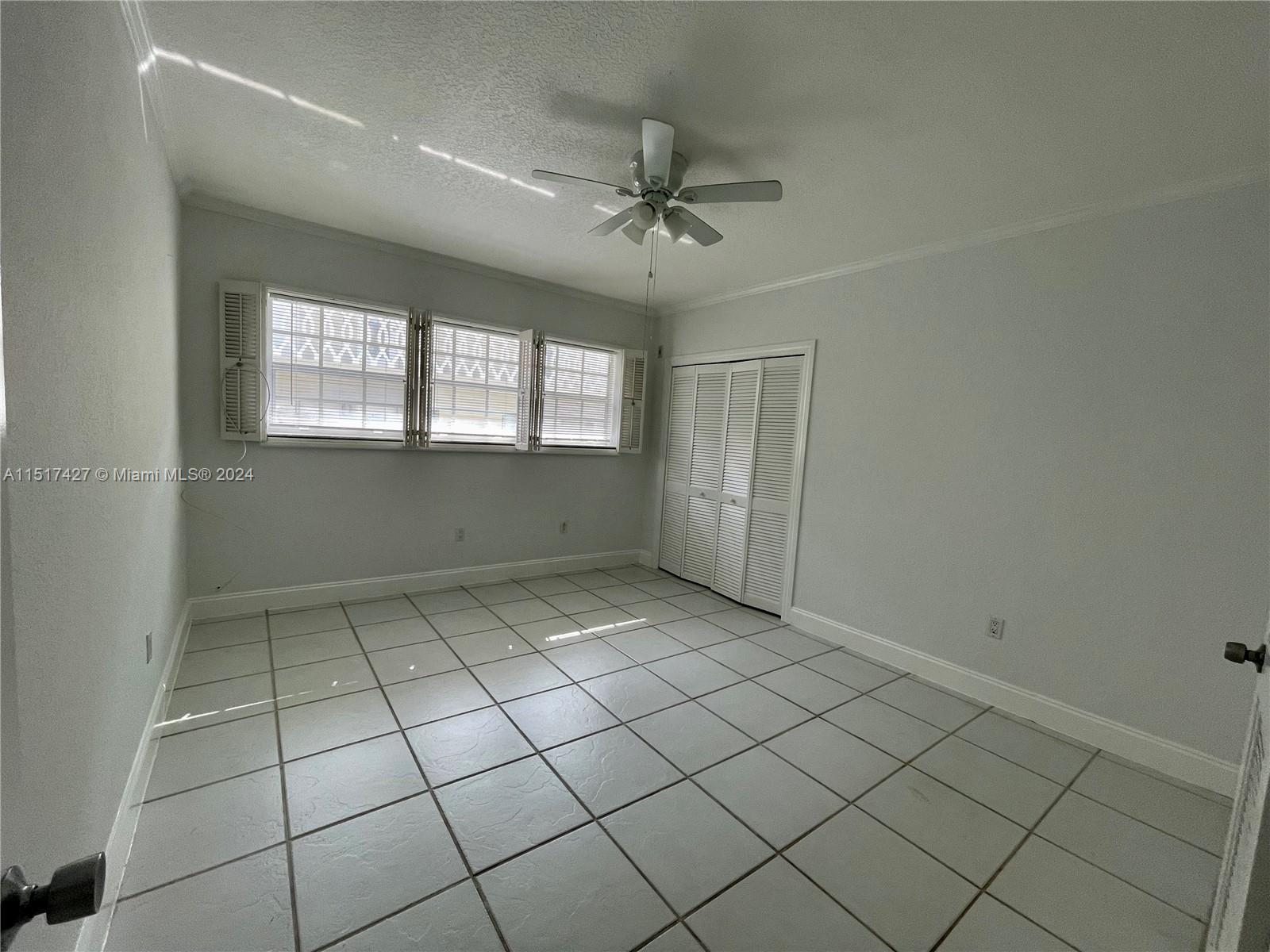 462 Golden Isles Drive, Unit 210 Hallandale Beach, FL 33009 - Photo 30 of 41 an empty room with windows and ceiling fan