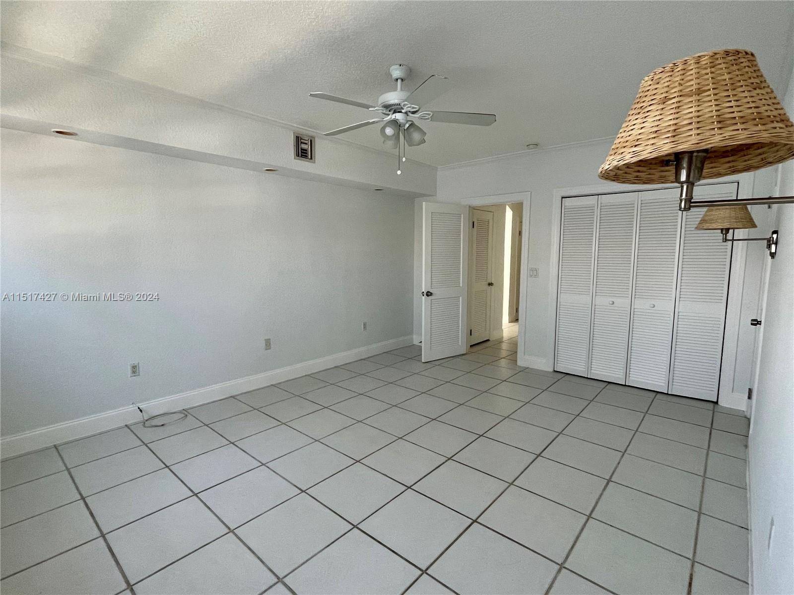 462 Golden Isles Drive, Unit 210 Hallandale Beach, FL 33009 - Photo 36 of 41 an empty room and chandelier fan view