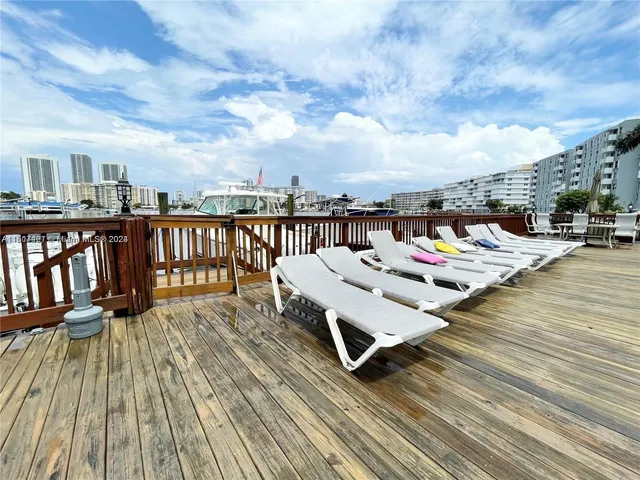 a balcony with wooden floor table and chairs