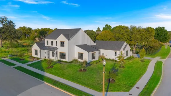 a view of a big house with a big yard and plants