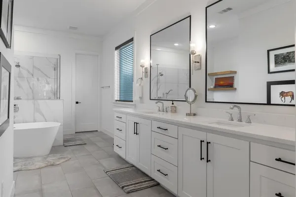 a spacious bathroom with a double vanity sink mirror and bathtub
