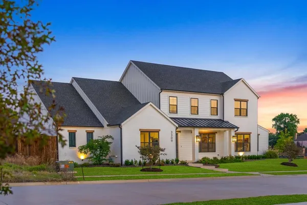 a front view of a house with a garden and plants