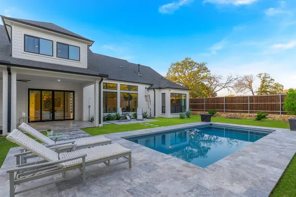 a view of an house with swimming pool and a yard