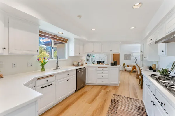 a kitchen with white cabinets and white appliances