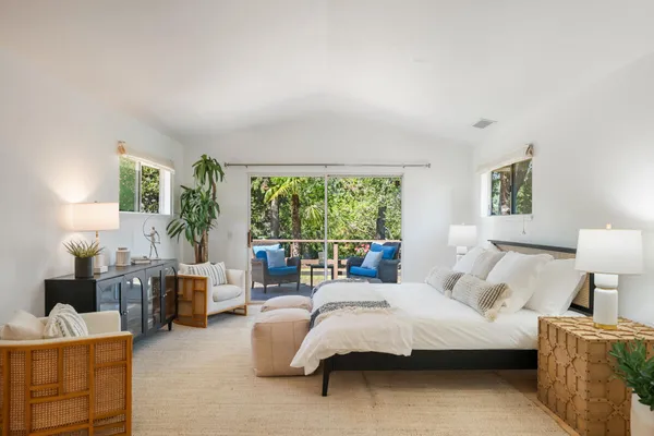 a bedroom with furniture and a large window