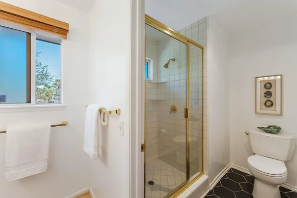 a bathroom with a toilet and a shower