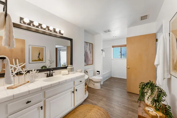 a spacious bathroom with a double vanity sink a mirror and a shower