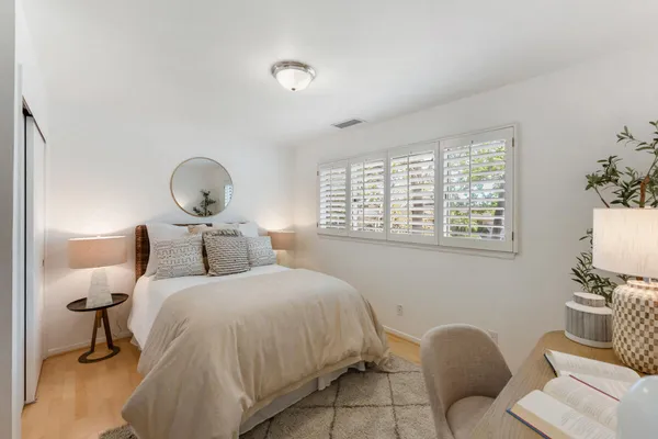 a bedroom with a bed and wooden floor