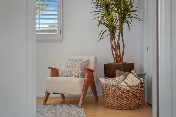 a living room with furniture a window and a potted plant
