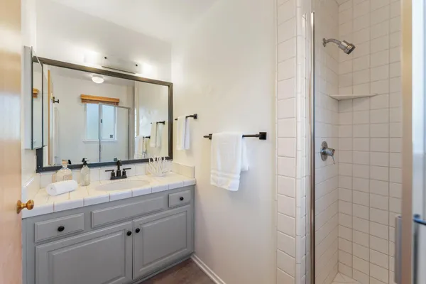 a bathroom with a double vanity sink mirror and shower