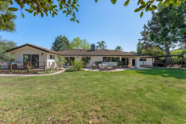 a front view of a house with swimming pool having outdoor seating