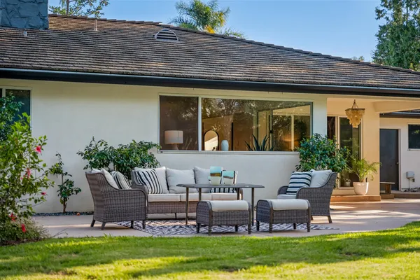 a view of a house with a backyard and sitting area